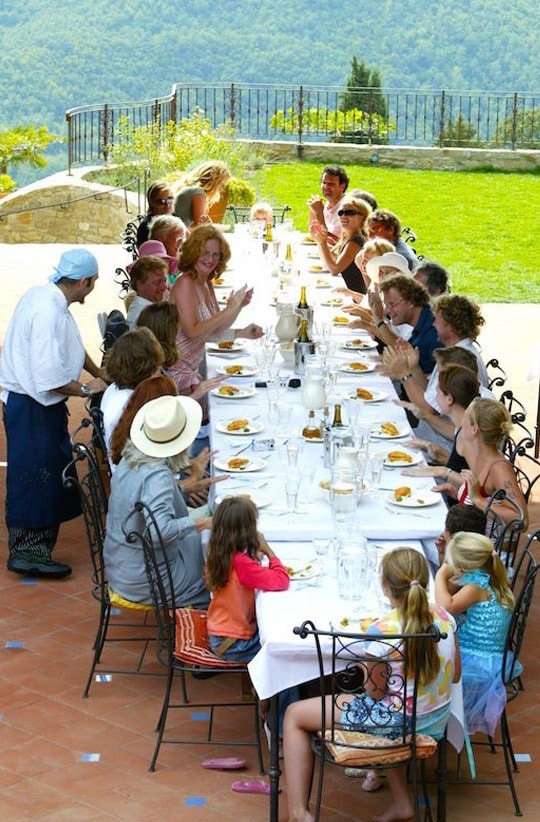 Family gathered around a long outdoor dining table